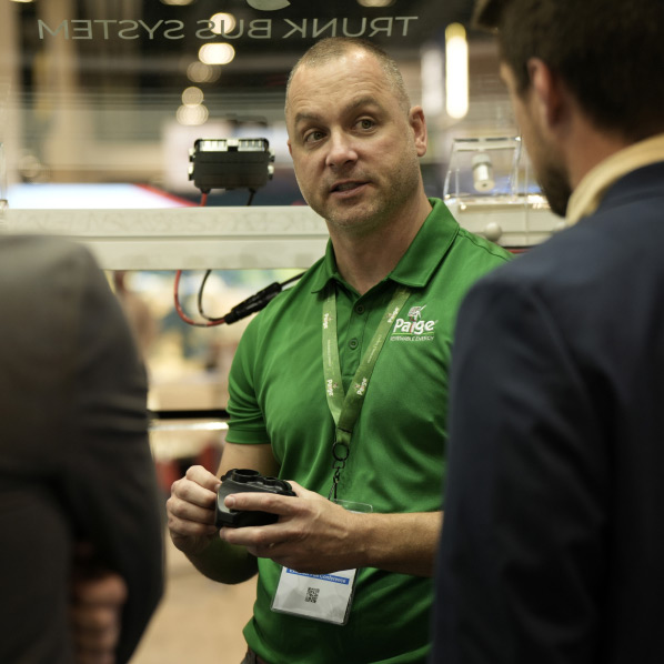 Mason Philips talking to people at a tradeshow while holding the IPC.